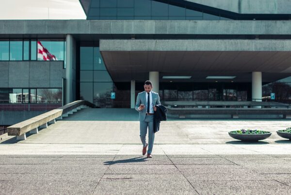 Avocat d’affaires sortant d’un immeuble de bureaux moderne : choisir entre SELARL ou SELAS