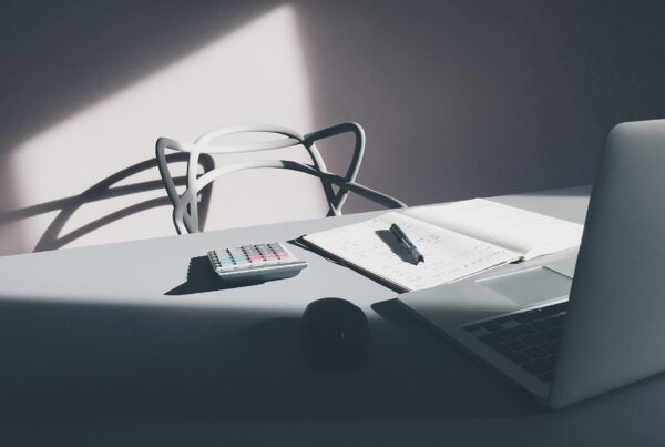 Bureau avec ordinateur portable et calculatrice pour suivre les frais professionnels déductibles d’un avocat