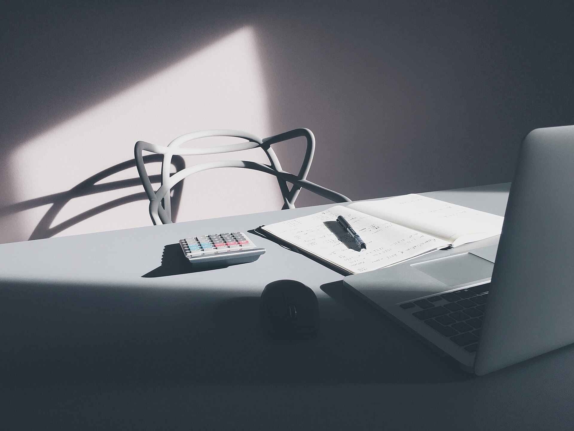 Bureau avec ordinateur portable et calculatrice pour suivre les frais professionnels déductibles d’un avocat